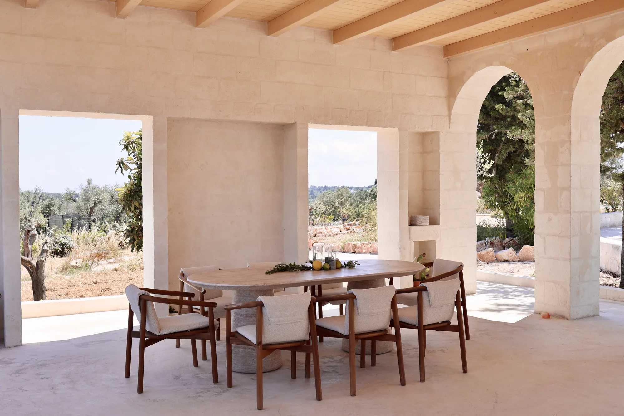 The loggia: oval table laid under the arches, facing the valley