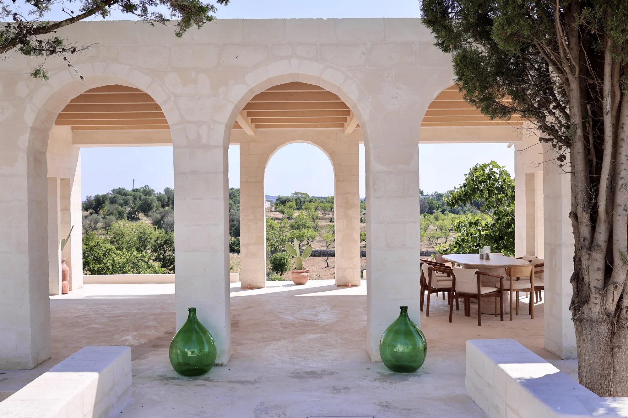 The loggia colonnade with green demijohns and the dining table